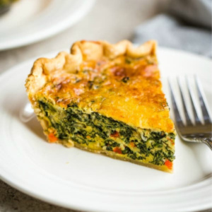 A piece of spinach quiche on a plate