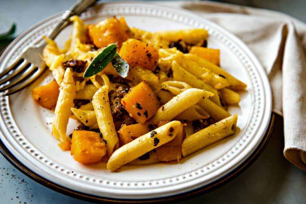 Butternut Squash Italian Sausage Pasta Bake on a white plate with fork