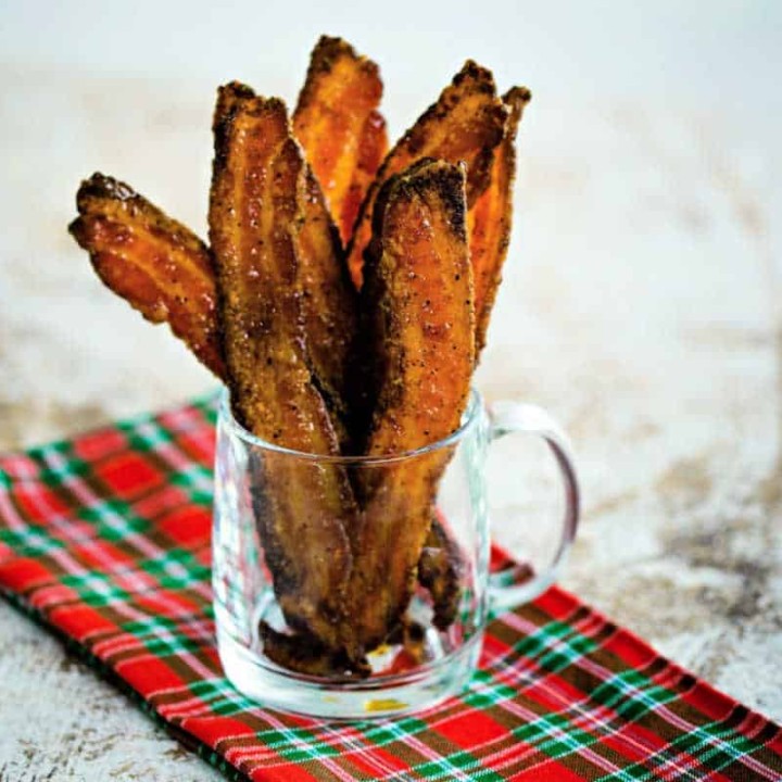 slices of sugared pepper bacon in a clear glass mug