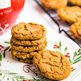 ginger cookies on a baking rack with a plate with a stack of cookies