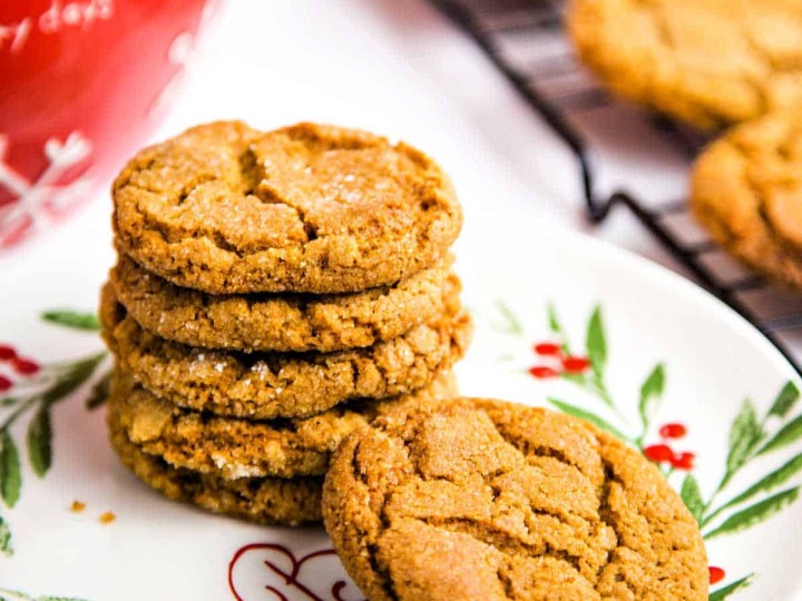 ginger cookies on a baking rack with a plate with a stack of cookies