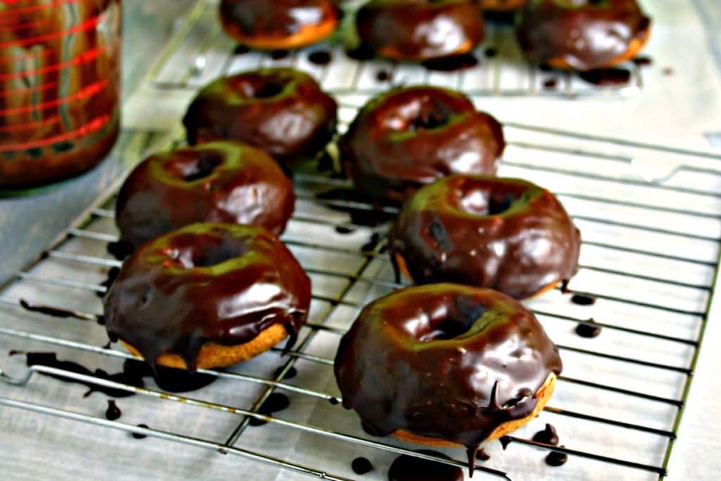 A doughnut sitting on top of a metal rack, with Mocha Glazed Baked Donuts