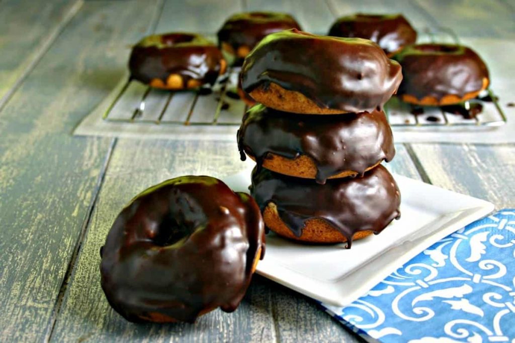 A chocolate doughnut on a plate, with Mocha Glazed Baked Donuts