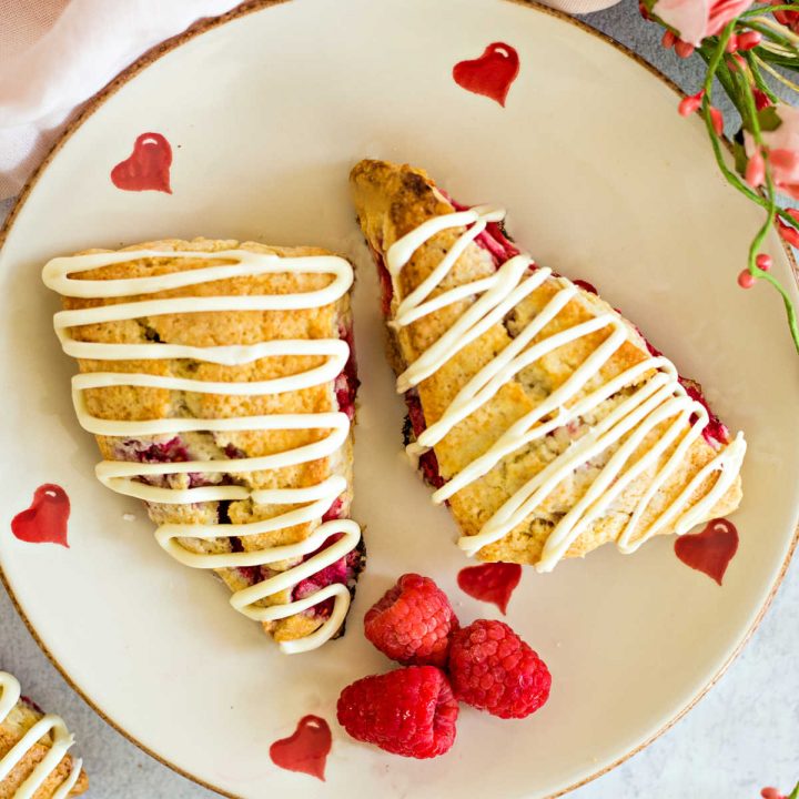 raspberry scones on a Valentine heart plate with roses o a table