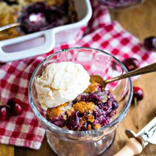 a bowl of cherry cobbler with a scoop of ice cream on top