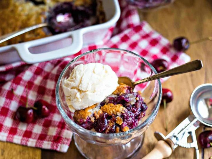 a bowl of cherry cobbler with a scoop of ice cream on top