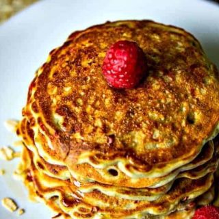 stack of raspberry pancakes on a white plate