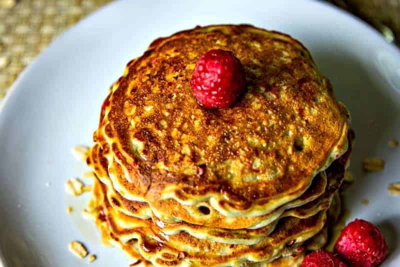 stack of raspberry pancakes on a white plate