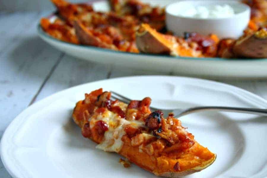 A plate of food with a piece of loaded sweet potato skins