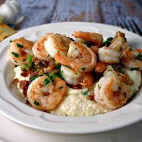 A plate of Smokey Shrimp and Grits on a table