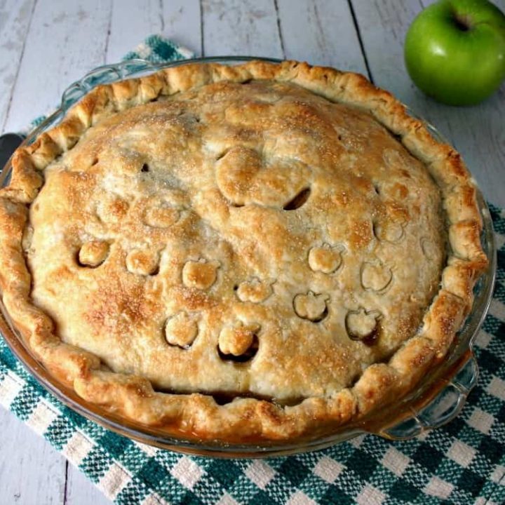 An apple pie sitting on top of a wooden table