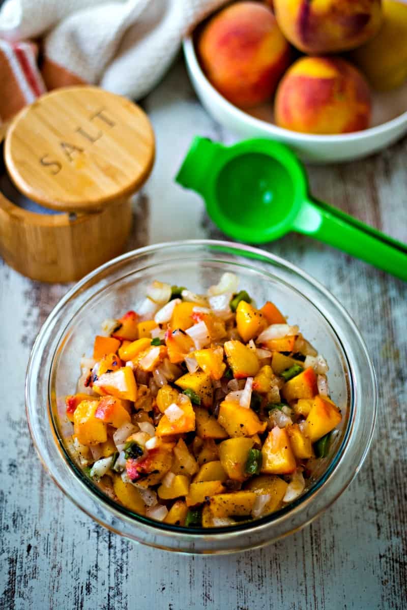 a bowl of peaches on counter with a bowl of peach salsa