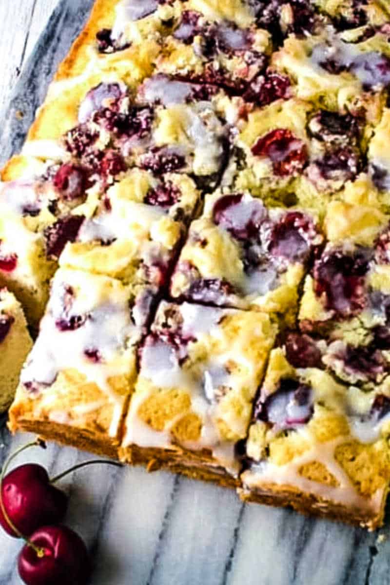 cherry cake cut into squares on a marble board