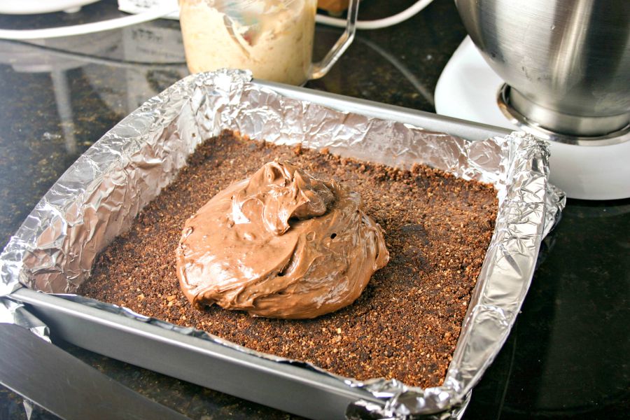 A pan filled with chocolate crust, and cheesecake filling