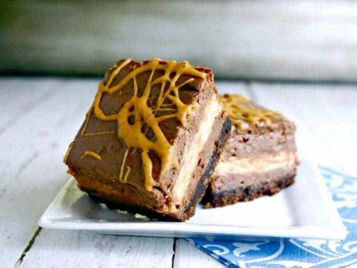 A slice of chocolate peanut butter cheesecake squares on a plate