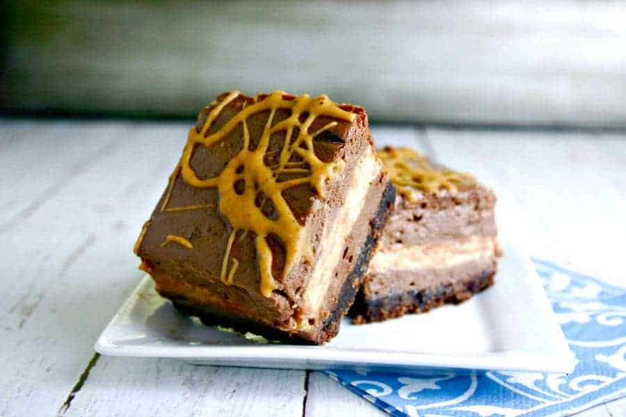 A slice of chocolate peanut butter cheesecake squares on a plate