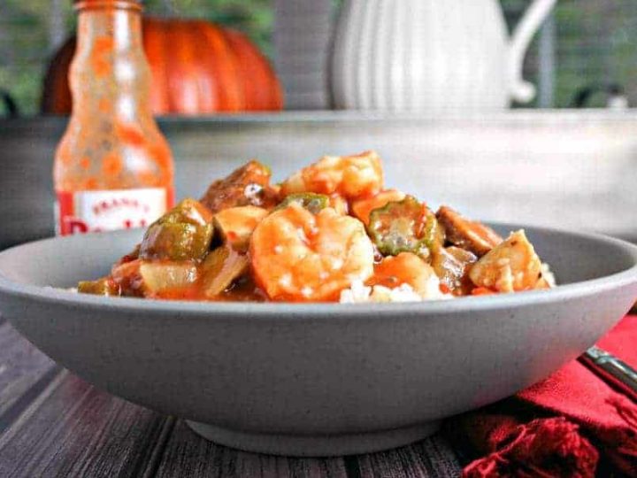 A bowl of food on a table, with Chicken, Sausage, and Shrimp Gumbo