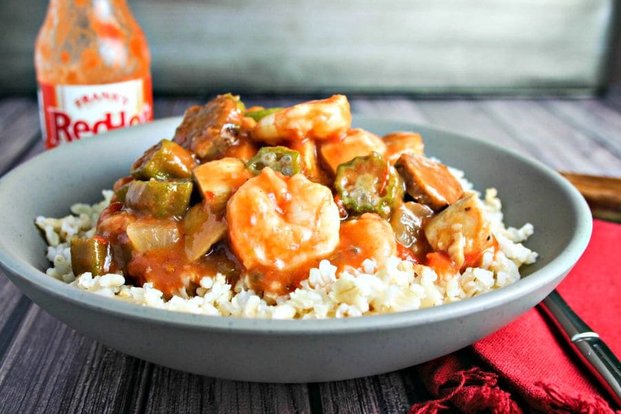 A bowl of food on a table, with Chicken, Sausage, and Shrimp Gumbo