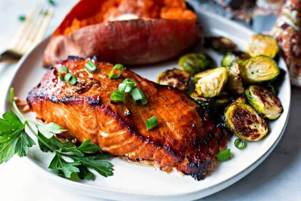 Best Grilled Salmon on a white plate with baked sweet potato