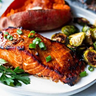 Best Grilled Salmon on a white plate with baked sweet potato