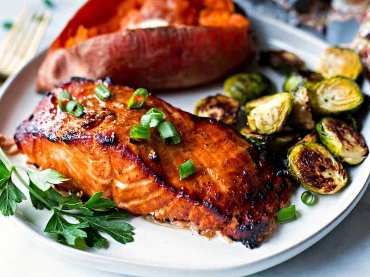 Best Grilled Salmon on a white plate with baked sweet potato