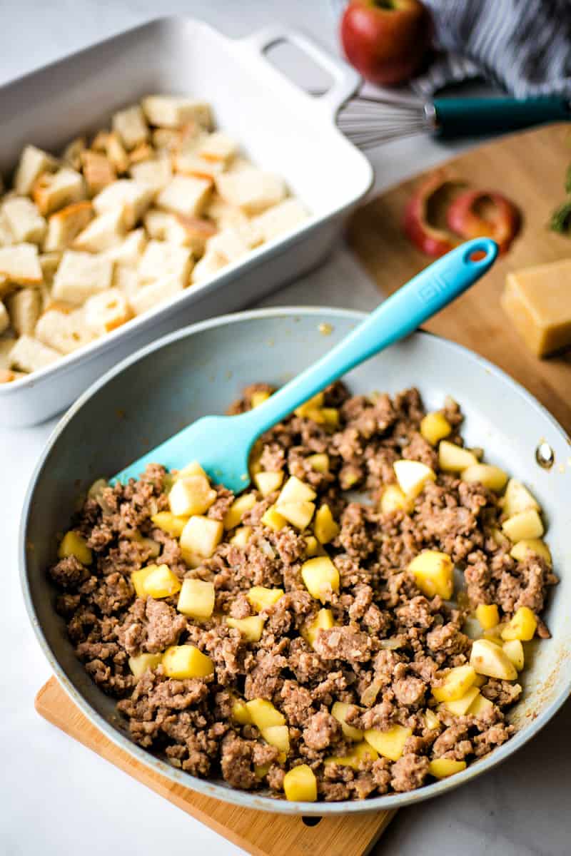 Fried sausage and apples in a frying pan