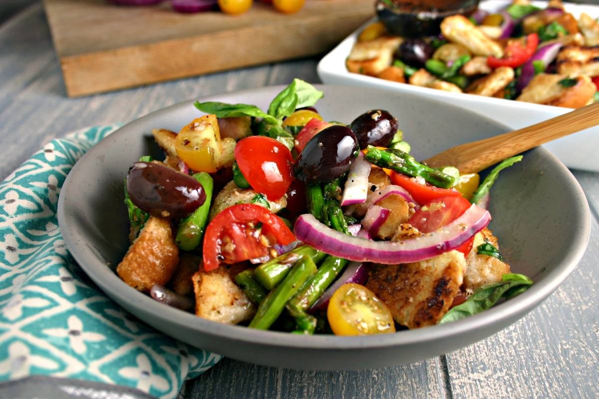 A bowl of Grilled Asparagus Panzanella Salad on a table