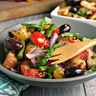 A bowl of Grilled Asparagus Panzanella Salad on a table