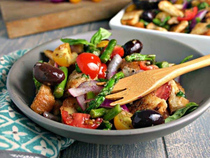A bowl of Grilled Asparagus Panzanella Salad on a table