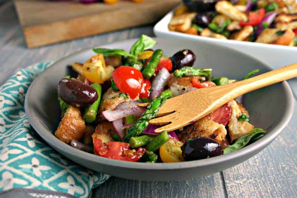 A bowl of Grilled Asparagus Panzanella Salad on a table