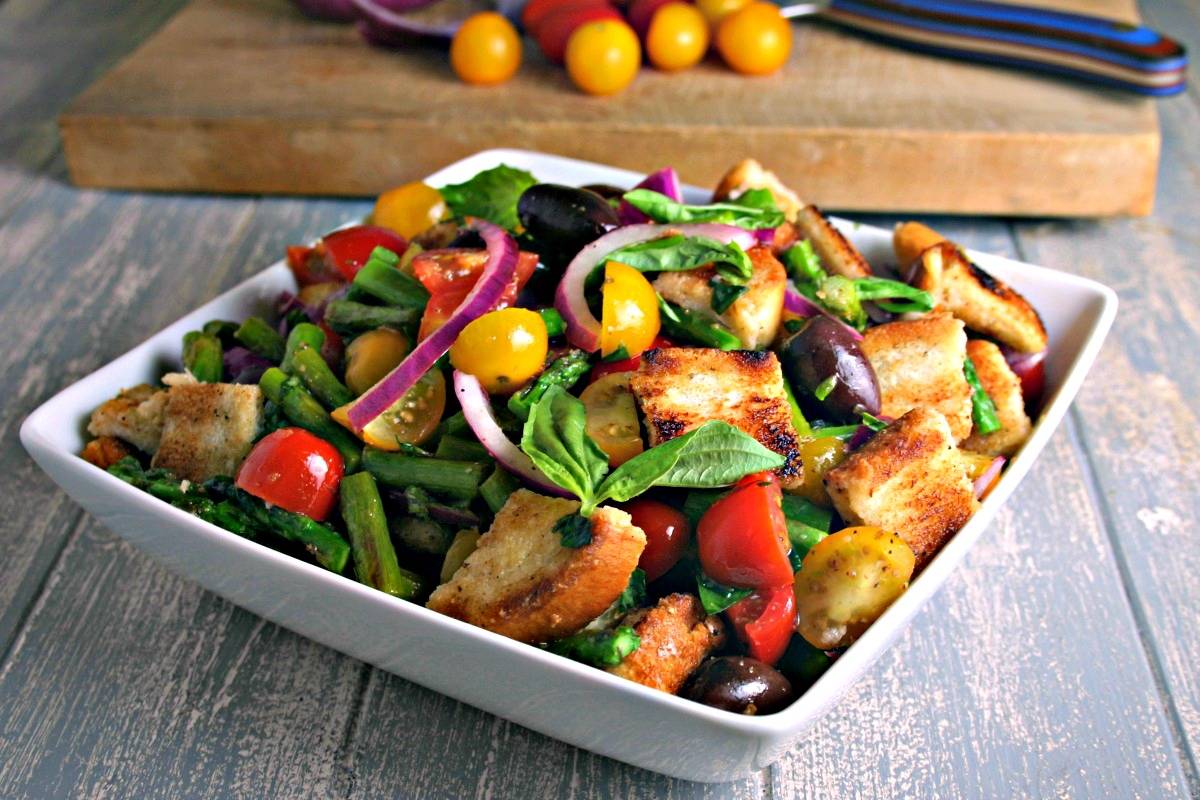 A bowl of Grilled Asparagus Panzanella Salad on a table