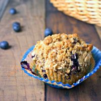 A muffin sitting on top of a wooden table, with Blueberry Oatmeal Muffins