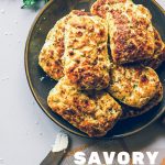 Savory Ricotta Scones on a plate with a bundle of fresh herbs on a table