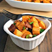 A bowl of food on a plate, with Sweet Potato salad