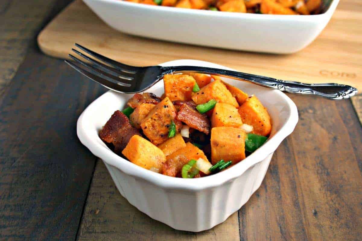 A bowl of food on a plate, with Sweet Potato salad