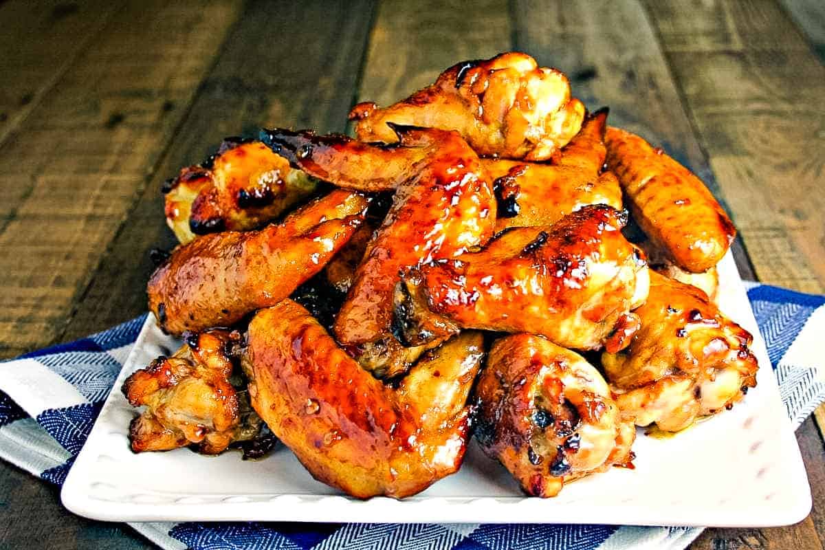 A plate of food, with Sticky Baked Chicken Wings