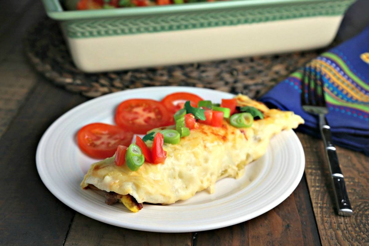 A plate of food on a table, with breakfast enchiladas