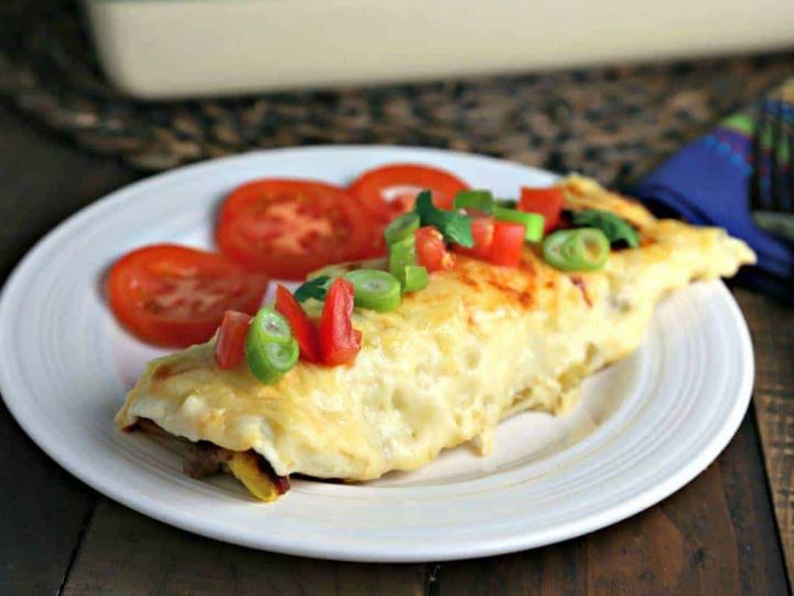 A plate of food on a table, with breakfast enchiladas
