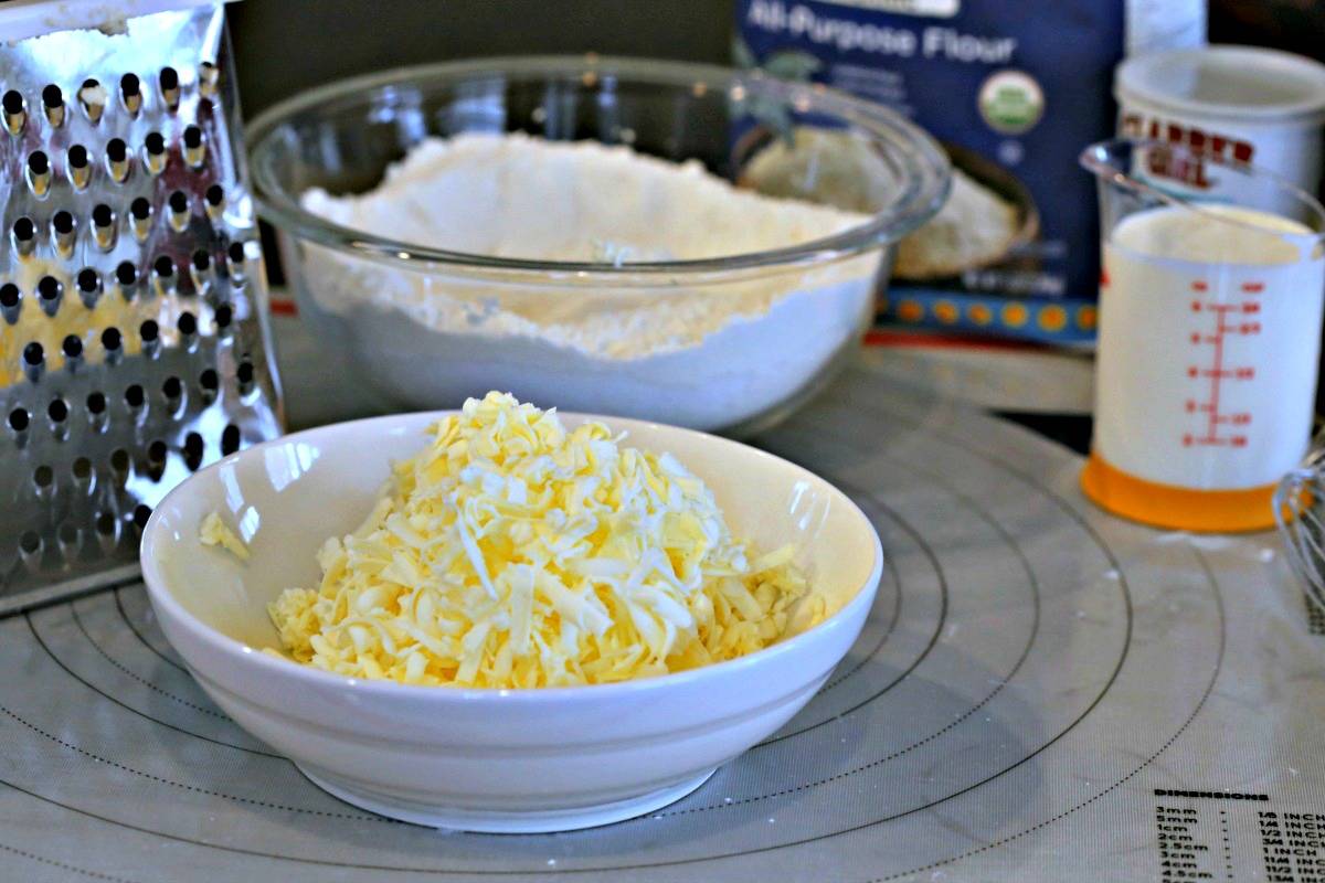 A bowl of flour and butter on a table, with White Chocolate Cranberry Scones 