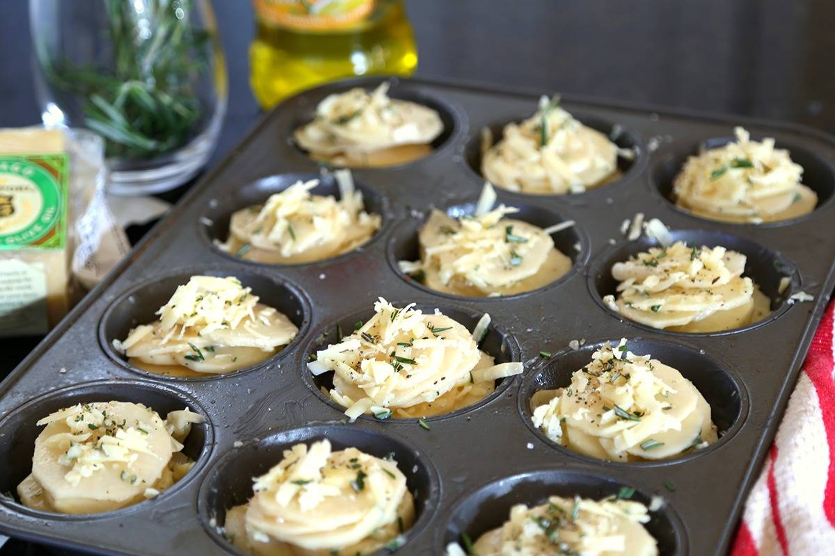 Potato slices stacked in a muffin pan, with Asiago Potato Stacks
