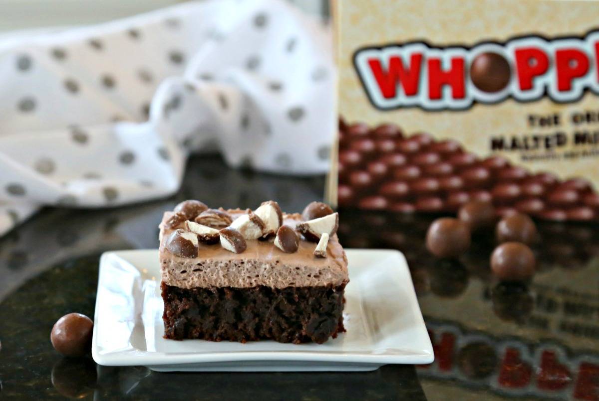 A Malted Mousse Brownie on a white plate sitting on top of a table