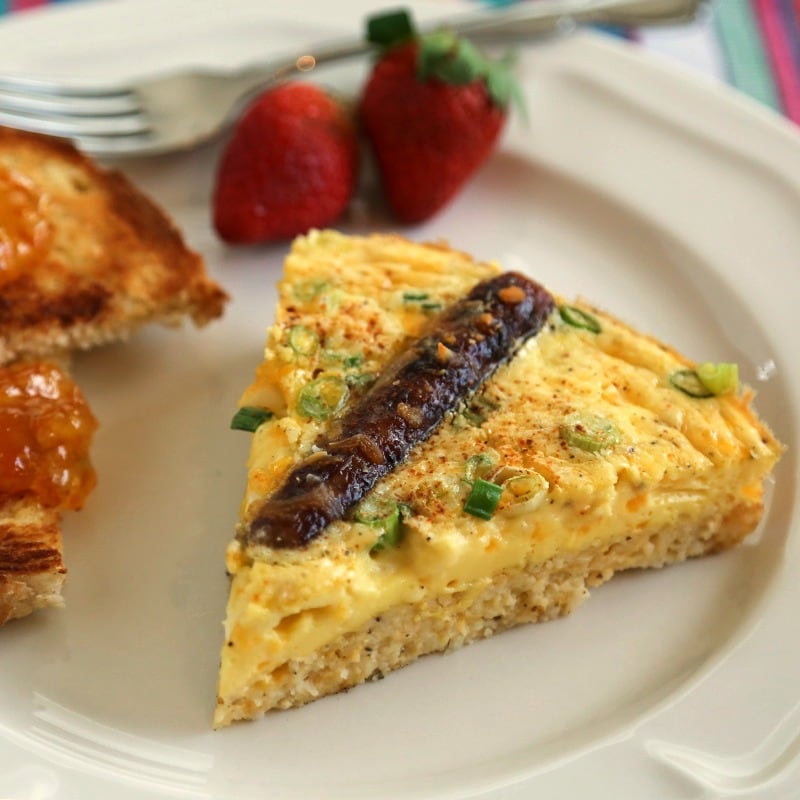 A plate of food with a slice of Rustic Sausage and Grits Egg Skillet