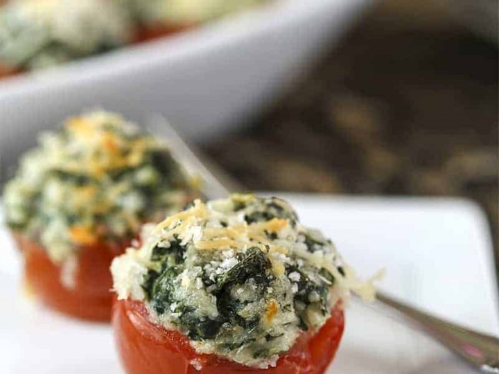 A plate of Spinach Stuffed Tomatoes on a table