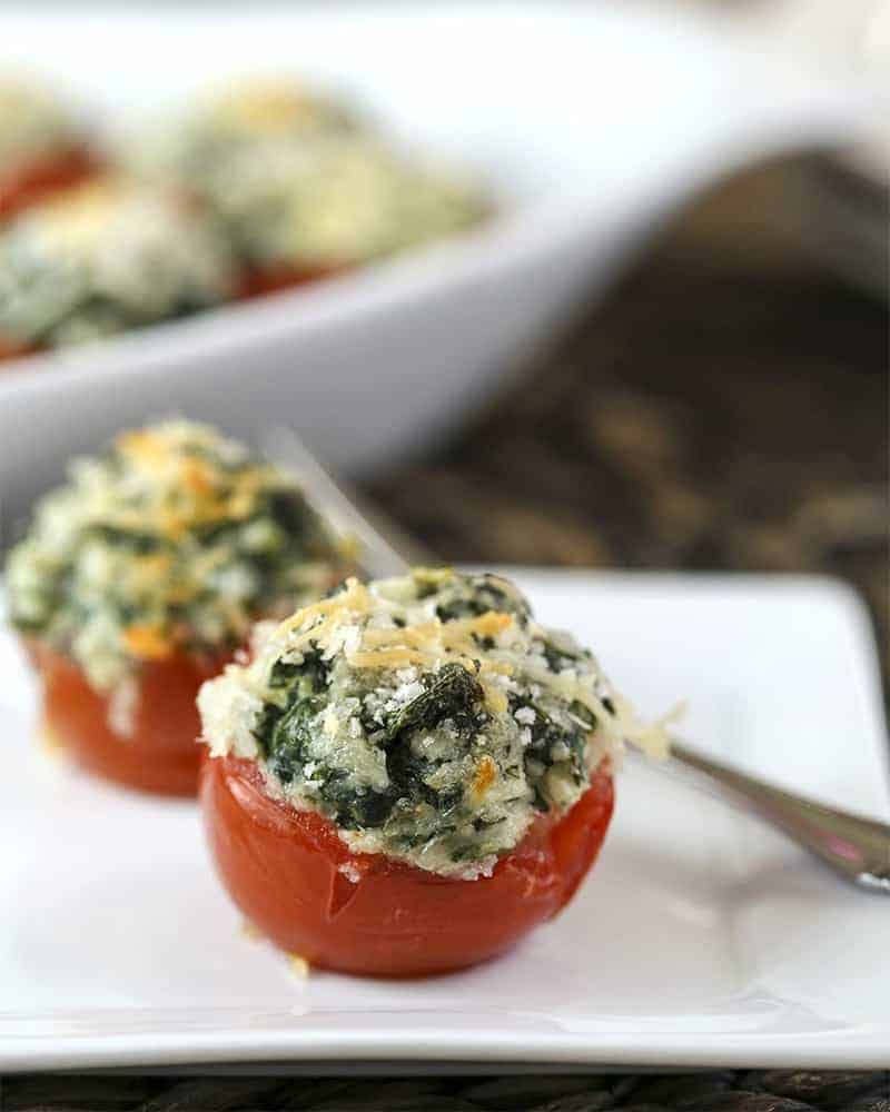 A plate of Spinach Stuffed Tomatoes on a table