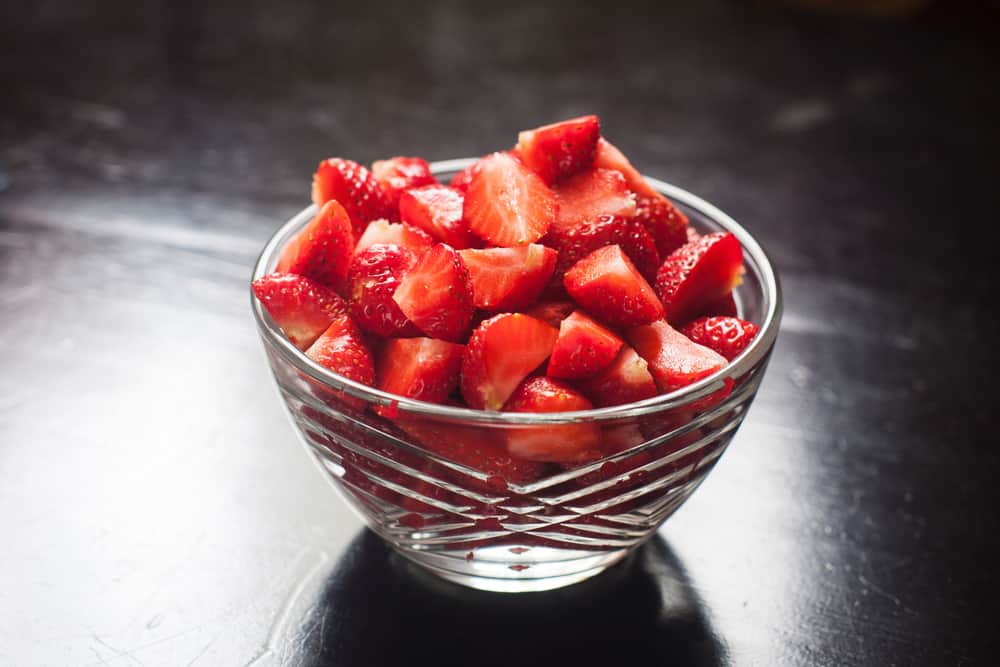 cut up strawberries in a glass bowl