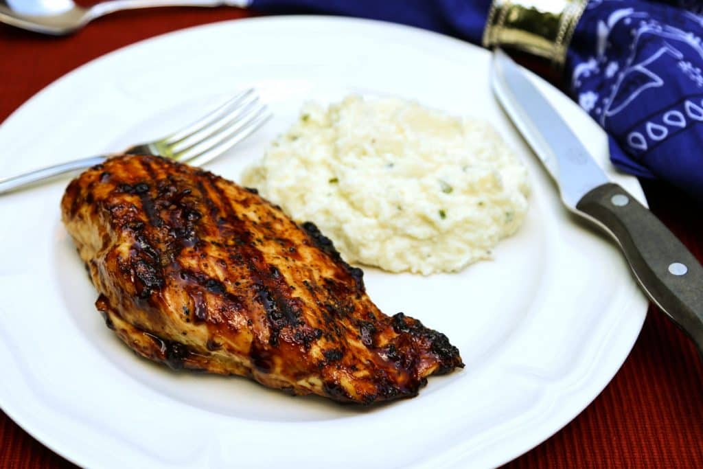 A plate of food with a fork, with balsamic grilled chicken