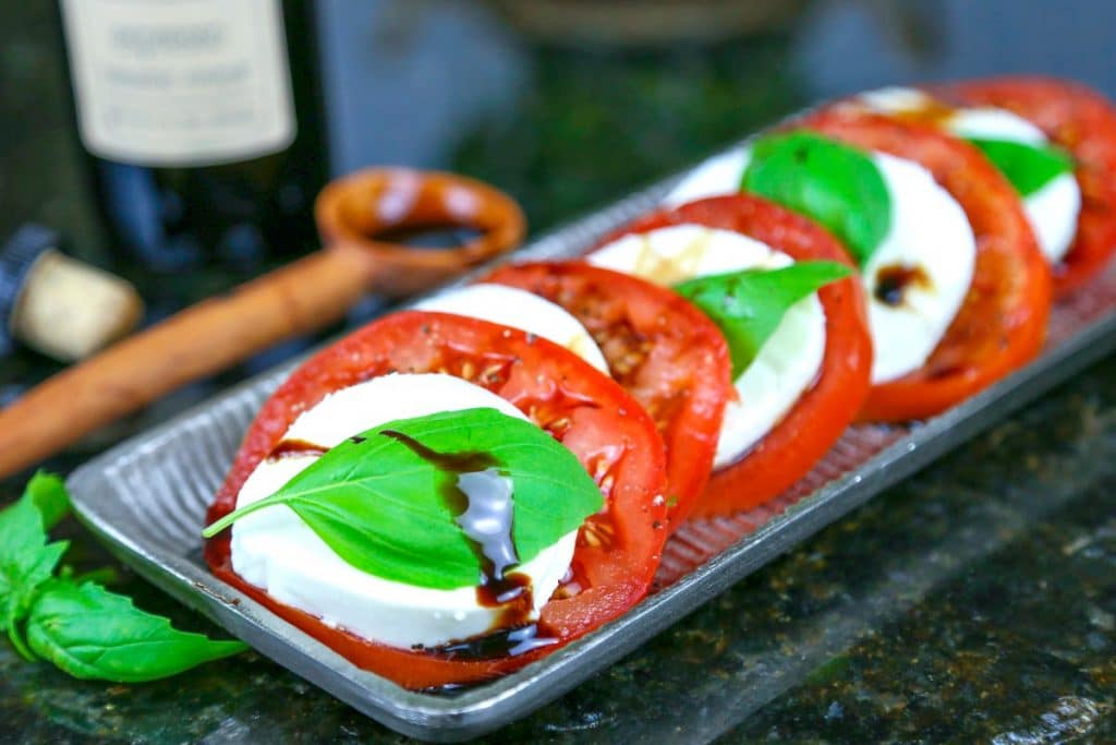 A tray of caprese salad with fresh basil