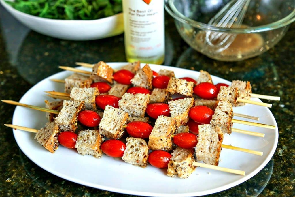 A plate of bread and tomato skewers