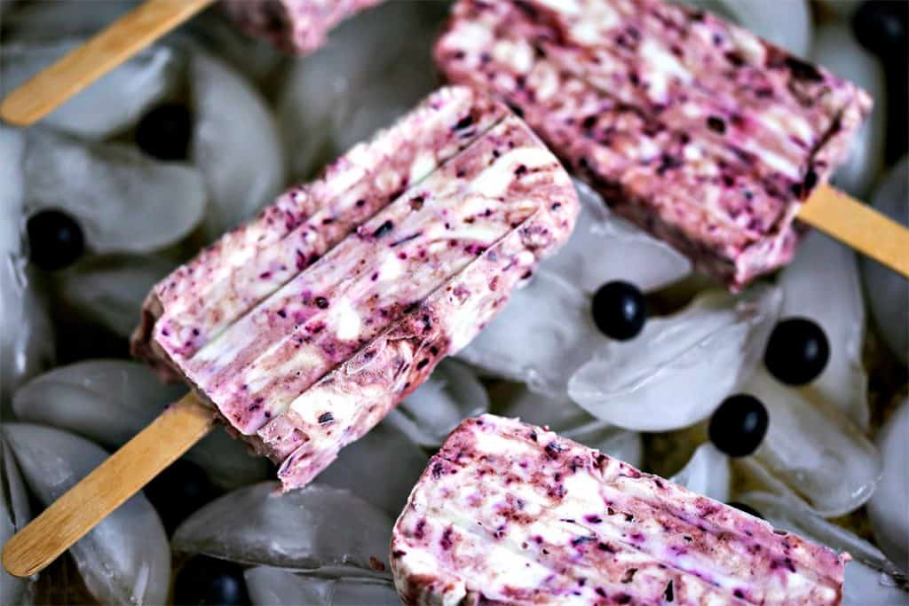 A close up of a A blueberry cheesecake popsicle