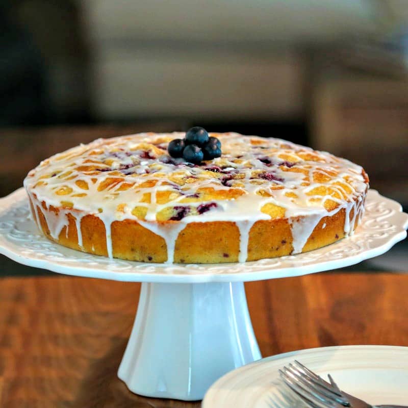 Blueberry Coffee Cake on a cake stand on top of a table